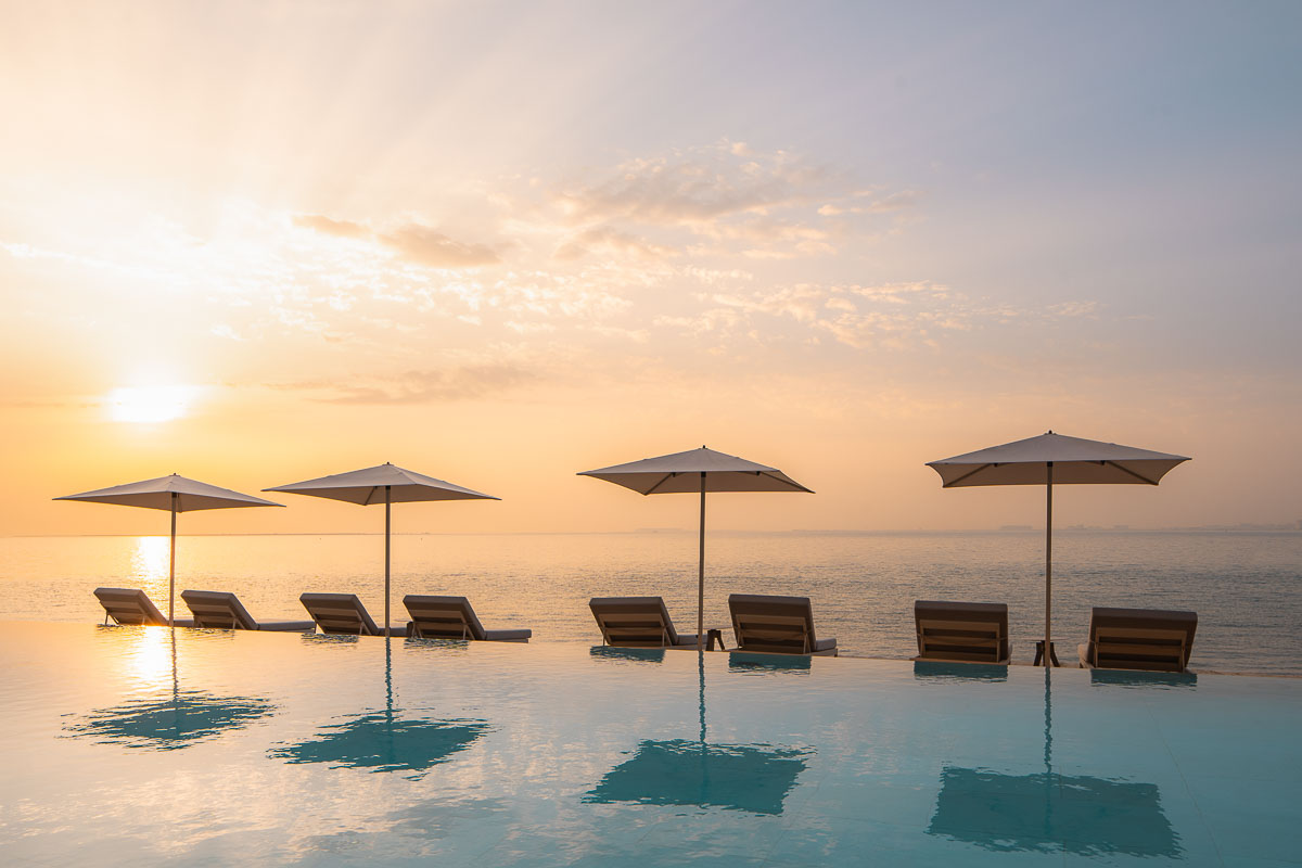 Beach umbrellas and loungers are the perfect viewing spot for sunsets over water.