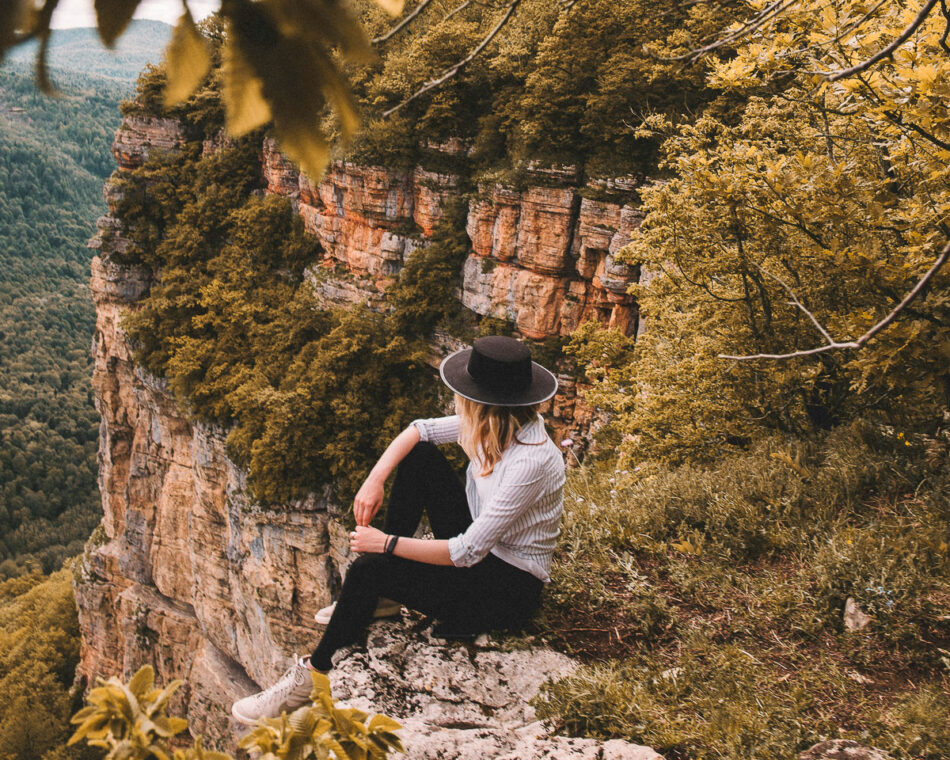 A mountain climber takes a break at a lookout.