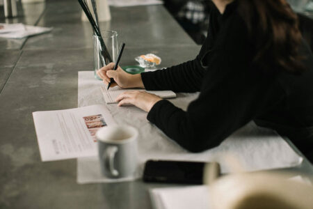 A woman learns how to write fast at an oversized desk.