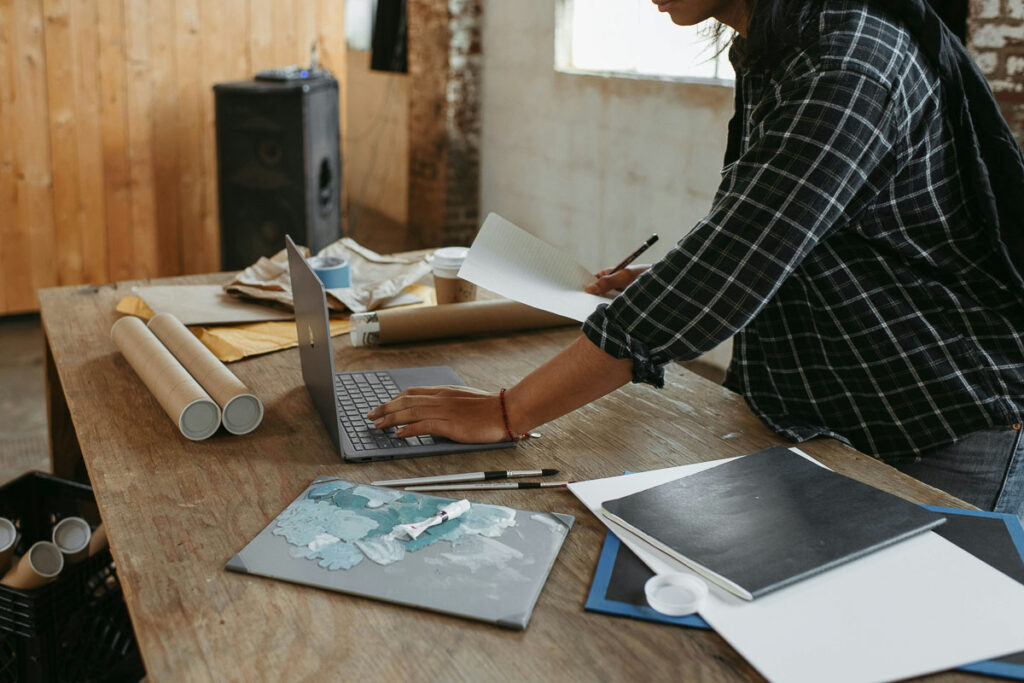 A man works on his laptop in a creative studio space.