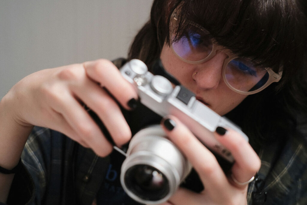 A woman examines her camera settings.