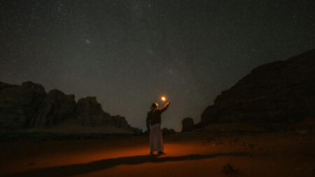 A lone camper lights the night sky.