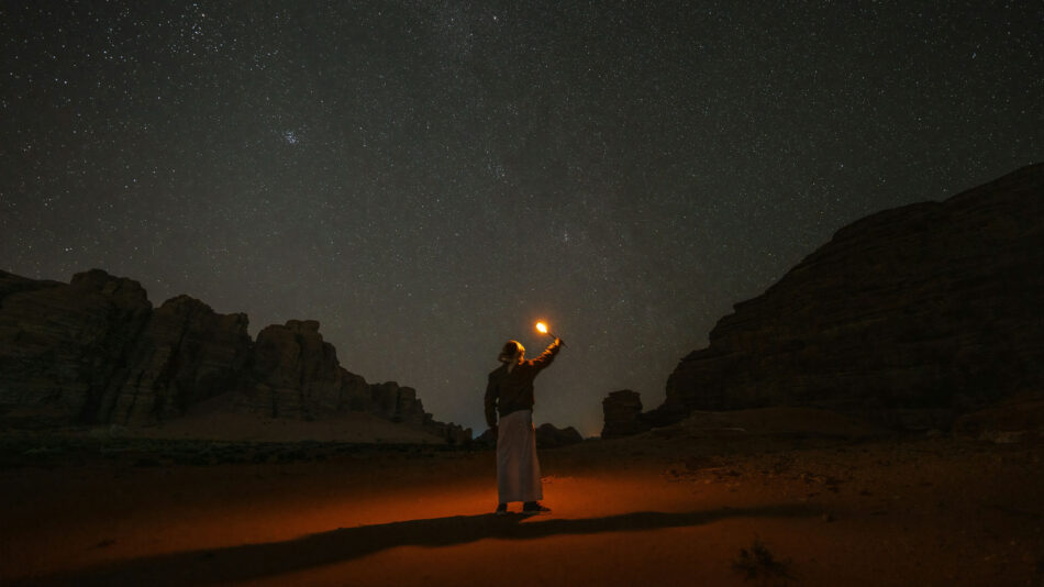 A lone camper lights the night sky.